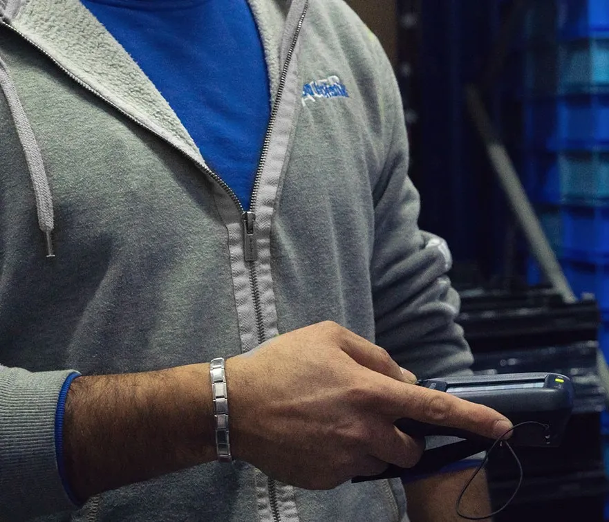 Mitarbeiter von Clean Logistik Jäger scannt KLT-Behälter mit einem Handscanner im Lager. Digitale Prozesse für effiziente Logistik und Lagerverwaltung.